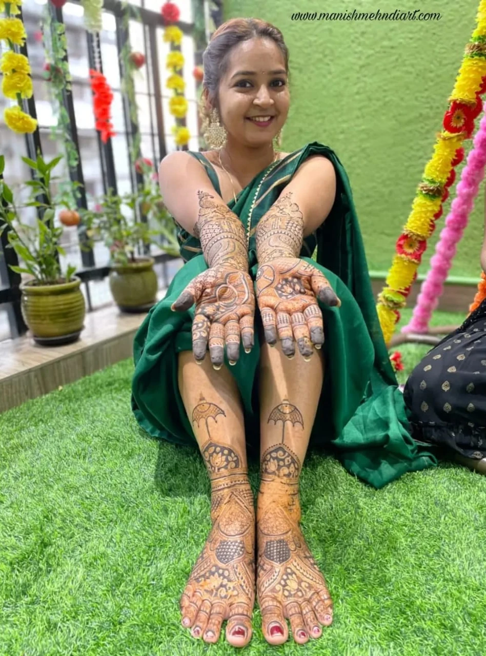 Bride in green saree showing full hand and feet mehndi